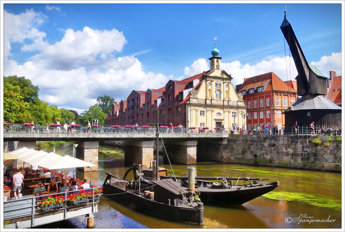 Historischer Hafen an der Ilmenau in Lneburg. Links ein Straencaf und rechts der  Alte Krahn . August 2024.  