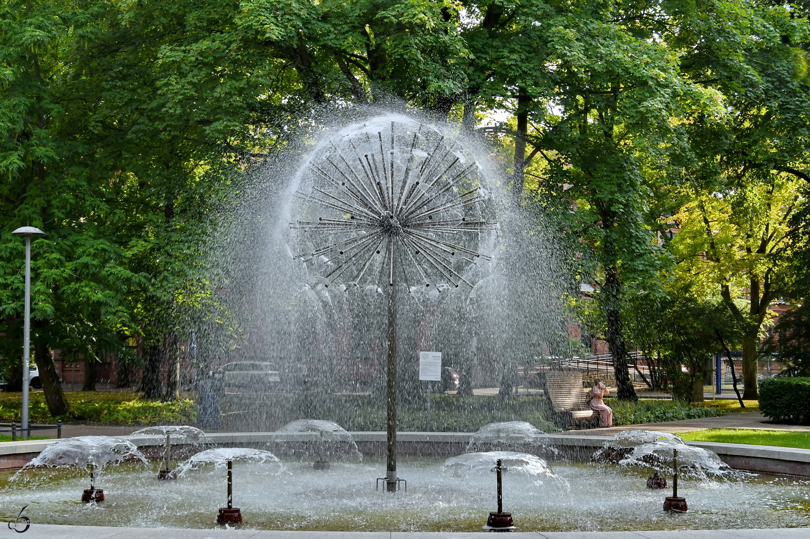 Der Lwenzahnbrunnen befindet sich im Zentrum des Platz des 18. Mrz, so gesehen Anfang September 2024 in Kolberg (Kołobrzeg).