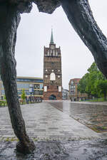 Das Kr�peliner Tor in Rostock, gesehen durch die Beine der Skulptur �Schreiender Hengst�.