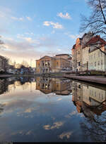 Ruhige Abendstimmung: Im Wasser des Brunnens auf dem Juliot-Curie-Platz in Halle (Saale) spiegelt sich das Opernhaus.