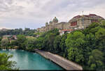 Oberhalb der Aare erhebt sich in Bern das Bundeshaus der Schweiz.