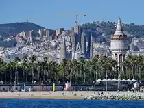 Blick vom Wasser auf den Strand von Barcelona, im Hintergrund deutlich zu erkennen der 45 Meter hohe Wasserturm  Torre d’aig�es de la Catalana de Gas  und die  ewige Baustelle  Sagrada Fam�lia. (November 2022)

