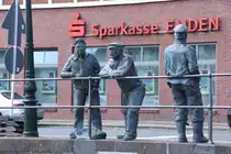 EMDEN, 21.06.2022, ein Skulpturen-Ensemble von Fischern am Ratsdelft, genannt Delftspucker; die beiden dem Wasser zugewandten Figuren sto�en tats�chlich ab und zu Wasser aus