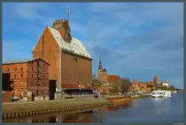 Zahlreiche Backsteinbauten pr�gen den Hafen von Tangerm�nde. Vorn sind zwei Speicher zu sehen, rechts davon die Kirche St. Stephan und die davor befindliche Stadtmauer. Am rechten Rand befindet sich die Burg Tangerm�nde. Im Hafen liegt am 05.02.2023 ein Flusskreuzfahrtschiff vor Anker.