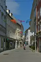 Blick in eine Menschenleere Stra�e, mit verzierten Geflechten �ber unseren K�pfen, in St. P�lten. 03.06.2023