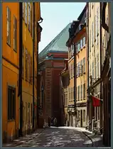 Zahlreiche kleine Gassen mit historischen Wohn- und Gesch�ftsh�usern f�hren durch die Altstadt von Stockholm. Durch die Svartmangatan f�llt der Blick auf die Deutsche Kirche St. Gertrud (Tyska kyrkan). (Stockholm, 18.05.2023)
