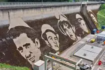 Dieses verg�ngliche Kunstwerk, geschaffen von Klaus Dauven im Jahr 2023, auf der Staumauer in Vianden.
Die Gesichter stellen Arbeiter dar, die am Bau der Staumauer in den 1950 – 1960er Jahren beteiligt waren. 
Das Kunstwerk wird in ca 5 - 6 Jahren nicht mehr zu sehen sein. 05.2024

