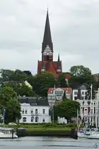 Blick �ber das Hafenbecken auf den Flensburger Stadtteil J�rgensby mit dem charakteristischen Turm der Kirche St. J�rgen. (Juni 2024)