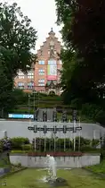 Der 1967 errichtete Maskenbrunnen befindet sich unterhalb des Museumsberges in Flensburg. (Juni 2024)