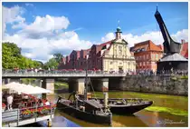 Historischer Hafen an der Ilmenau in L�neburg. Links ein Stra�encaf� und rechts der  Alte Krahn . August 2024.  