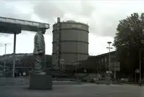 Skulptur  Stahlarbeiter  und Gasometer in V�lklingen am 16. Juni 2024. Aufgenommen mit einer Minolta Dynax 3xi und einem Agfa 100 s/w Film 