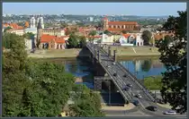 Die Vytautas-Magnus-Br�cke verbindet den Stadtteil  Aleksotas mit der Altstadt von Kaunas, die zwischen den Fl�ssen Neris und Memel liegt. Links sind die Vytautas Magnus-Kirche und dahinter die Jesuitenkirche zu sehen. Rechts ist am Flussufer die evangelisch-lutherische Kirche und dahinter die Kathedrale St. Peter und Paul zu erkennen. (Kaunas, 05.09.2024)