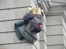 Der  L�llek�nig  an der Fassade des Hauses Schiffl�nde 1 in Basel gegen�ber der Mittleren Br�cke am 24.12.24. Die Figur streckt den �ber die Br�cke kommenden Besuchern die Zunge heraus ( L�lli  ist ein baseldeutsches Wort f�r Zunge). Anlass und Sinn des L�llek�nigs sind nicht bekannt. Der dargestellte Kopf wurde 1914 an dem Haus angebracht.