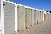 An der n�rdlichen Mauer vomFriedhofauf der d�nischen Nordseeinsel R�m (d�nisch R�m�)  findet sich eine Sammlung von 36 Grabsteinen wohlhabender Walfangkapit�ne: die Kommand�r-Steine. Jene Kommand�r-Steine sind Grabplatten, welche 1964 zum Schutz gegen die Witterung an der zur Sonne ausgerichteten Mauer angebracht wurden. Aufnahme: 19. Mai 2025.