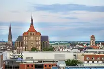 Blick �ber Rostock nach S�den von der Dachterrasse �ber dem Restaurant KAI40. Links ist die Petrikirche zu sehen, in der Mitte die Marienkirche und rechts die Nikolaikirche. Aufnahme: 7. Juni 2025.