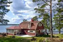 Holzhaus, gestrichen in Falunrot. Das Haus liegt an der S�dspitze von Gr�ns� bei V�stervik in Sm�land, Schweden. Aufnahme: 20. August 2025.