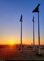 Morgendlicher Stopp beim Joggen auf dem Aussichtsh�gel Heide-S�d. Neben den fahnenartigen Masten geht die Sonne auf – ein klarer Wintertag k�ndigt sich an.

🕓 5.12.2024 | 8:20 Uhr