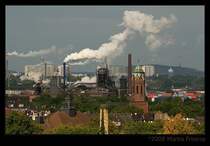 Blick �ber Duisburg Hochfeld und Homberg Richtung Moers. Leider kann ich nicht viele Geb�ude zuordnen, aber mittig rechts ist der Turm der Pauluskirche Hochfeld zu sehen. Ein Teil der Industrieanlagen links davon geh�ren wahrscheinlich zur ehemaligen Duisburger Kupferh�tte (heute DK-Recycling), links daneben sind Geb�ude von Maersk zu sehen (Au�enhafen), dahinter die Verstrebungen der A40-Autobahnbr�cke Homberg. Im Hintergrund der Funkturm Moers und rechts die Rheinpreussen-Halde mit dem Geleucht.