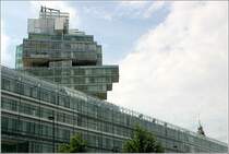 Zwei T�rme in Hannover: im Vordergrund das Hochhaus der Nord LB und rechts ist noch die Spitze des Rathausturmes zu erkennen.
Obwohl v�llig verschieden in ihrer Architektur, gibt es doch auch �hnlichkeiten. Beide T�rme sind von zu den jeweiligen Bauwerken geh�renden flacheren Bauteilen umgeben und beide pr�gen das Stadtbild. Das Bankgeb�ude wurde von den Stuttgarter Architekten Behnisch, Behnisch und Partner entworfen. 17.08.2006 (Matthias)