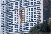 Hier ein Beispiel f�r den Einfluss von fung shui auf die Architektur. Um einem Drachen, der hinter dem hohen langgestreckten Geb�ude am Berghang wohnt, den Blick auf Strand und Meer nicht zu versperren, musste ein gro�es Loch ins Geb�ude eingebaut werden. Scan eines Dias aus dem Januar 1997.