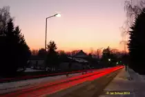 Niedersachsenstra�e in Spr�tze zur Blauen Stunde mit den R�cklichtern des Stra�enverkehrs in den Ort hinein.