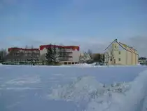 Grevesm�hlen, Wohnbl�ck mit dem Kustwerk -Wasserturm- an der Wismarschen Stra�e und die  Wasserturm -Schule im Ploggenseering im Winter 2009/2010