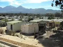 Am Rande der Siedlung entstehen mehr und mehr primitive Behausungen (Shaks).Im HIntergrund die Hottentots Berge. Sir Lovry's Pass Village, 06.12.2010
