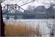 Blick auf die Potsdamer Seite der Glienicker Br�cke zwischen West-Berlin und Potsdam Ende der 1970er/Anfang der 1980er Jahre. Die sowjetische Fahne flattert im Wind, das DDR-Enblem h�ngt in der Br�ckenmitte. Das Winterwetter passt zu einem Agentenfilm mit Agentenaustausch. Scan vom Dia.