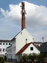 Wyhl am Kaiserstuhl, stillgelegter Schornstein mit Mehrfachnutzung, Sendemast und oben das Storchennest, Mai 2013
