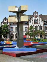 Brunnen auf dem Viktoriaplatz. Das neugotische Geb�ude im Hintergrund war einmal die Hauptpost, heute ist es das st�dtische Kunstmuseum (25. Mai 1989). Der Brunnen wurde von dem K�nstler Otto Herbert Hajek gestaltet. Die Meinungen dar�ber sind geteilt. Es ist jedoch zu ber�cksichtigen, dass sich die Konzeption des K�nstlers wohl nur bei der Draufsicht v�llig erschlie�t, die aber allenfalls aus den umgebenden H�usern m�glich ist.