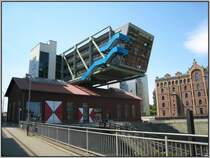 Am s�dlichen Ende des zum Medienhafen geh�renden Hafenbeckens  findet man den  Wolkenb�gel , der quer �ber ein altes, denkmalgesch�tztes Hafengeb�ude gebaut wurde. In dem alten Geb�ude befindet sich eine Diskothek, in dem Bauk�rper dar�ber u.a. B�ros. (15.07.2007)