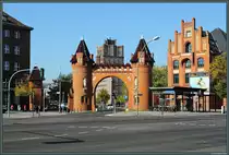 Die Borsigwerke waren in der Bl�tezeit der Eisenbahn der zweitgr��te Lokomotivenhersteller der Welt. Heute ist das Unternehmen im Industriemaschinienbau t�tig. Im Krieg wurden gro�e Teile der Fabrik zerst�rt, �brig blieben u.a. das eindrucksvolle Werkstor und der 1925 er�ffnete Borsigturm (im Hintergrund). Rechts befindet sich der Zugang zur U-Bahn-Station Borsigwerke. (Berlin-Tegel, 02.10.2013)