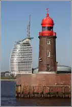 Bremerhaven. Ein alter und ein junger Turm als Nachbarn. Der kleine, 14 m hohe Leuchtturm auf der n�rdlichen Geestemole ist 1914 - also vor 100 Jahren - in Betrieb genommen worden. Das bis zur Spitze �ber 140 m hohe Atlantic Hotel Sail City wurde 2008 er�ffnet. 02.02.2014