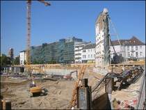 In den Jahren 2003 bis 2005 wurde in Karlsruhe am Rande der Innenstadt ein gro�es Einkaufszentrum gebaut, f�r das eine gro�e Fl�che freiger�umt werden musste. Im Bild sind ein kleiner Teil der Baugrube sowie die gerettete Fassade des Geb�udes von dem vorherigen Bild zu sehen. (22.09.2003) 