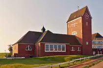 . Baltrum - Die Gro�e Inselkirche. 06.10.2014 (Jeanny)

Die Gro�e evangelisch-lutherische Inselkirche ist die Hauptkirche der evangelisch-lutherische Gemeinde und bietet Platz f�r 300 Personen. Sie wurde in den Jahren 1929/1930 als Ersatz f�r die Alte Inselkirche erbaut, die nach dem Ersten Weltkrieg aufgrund der stetig steigenden Zahl von Inselg�sten zu klein wurde. 1959 erhielt die Kirche ihre beiden Seitenschiffe, 1964/1965 wurde zudem der Kirchturm erh�ht und die bisherige Einzelglocke um zwei weitere kleinere Glocken erg�nzt.