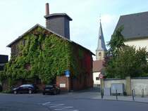 Die Stadt Rheda wurde bekannt durch eine vielschichtige Industrie. �ber�rtlich bekannte M�belbetriebe (L�bke & Rolf, COR, Disselkamp) und gro�e Fleischereien (Schulte KG und Schneider) sorgten f�r Arbeitspl�tze und Wohlstand nach 1945. Viele dieser Betriebe existieren heute nicht mehr. Hier sehen wir die Reste der alten Pottschen Brennerei mit einem Blick auf die ev. Kirche.