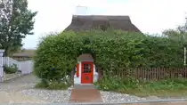 Reetdach gedecktes Haus in Ahrenshoop von einer hohen Hecke umgeben in der Stra�e  Weg zum Hohen Ufer  (Landkreis Vorpommern-R�gen, September 2012)