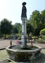 Blotzheim, der Brunnen am alten Rathaus von 1876, das Denkmal zeigt den ber�hmten Pfarrer des Ortes, Pere Bernadin Juif (1751-1836), Aug.2015