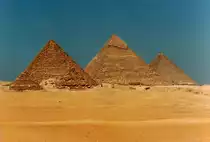 Die Pyramiden von Gizeh, von S�den gesehen; im Vordergrund die drei kleinen K�niginnenpyramiden, dahinter die Pyramide des Mykerinos, in der Mitte die des Chephren und rechts die des Cheops (�Gro�e Pyramide�). Aufnahme: April 1988 (digitalisiertes Negativfoto).