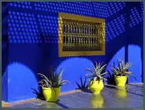 Das in dunklem Blau gehaltene Gartenhaus im Jardin Majorelle beherbergt ein Kunstmuseum. Hier ist ein Teil der Fassade mit einem filigran gestalteten Fenster zu sehen. (Marrakesch, 18.11.2015)