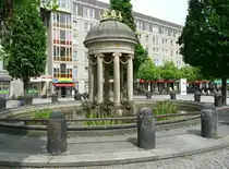 Dresden - der artesische Brunnen am Antonplatz in der Neustadt besteht aus 2 Teilen: einem Trinkbrunnen (ohne Trinkwasserqualit�t) und einem kleinen tempelartigen Rundbau mit Font�ne (etwa 1/2 m hoch. Das Wasser kommt aus einer Tiefe von 243,25 m und ist 17,8 Grad warm. Erbohrt wurde die Quelle 1832-1836, das Tempelchen stammt von 1906.
Aufgenommen im Mai 2012.