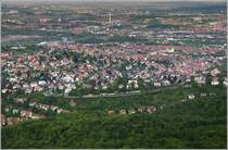 Blick vom Fernsehturm auf das Wohngebiet G�nsheide. Dahinter, dichter bebaut, liegt Ostheim. Oben in Bildmitte ist das Kraftwerk M�nster zu sehen. Rechts daneben das Neckartalviadukt der G�terumgehungsbahn. Links im oberen Drittel sind ein Teil der Abstellanlagen des Hauptbahnhofes zu erkennen.
Vorne am Rand der Bebauung f�hrt eine Stra�enbahn der Linie 15 auf der Pischekstra�e bergw�rts.