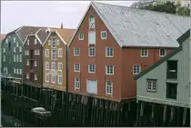 Trondheim. Die auf Pf�hlen stehenden Lagerh�user am Nidelva zeigen die typische, dreifarbige Farbgebung: wei�e Fensterrahmen, farbige Fensterumrandungen und Fassadenfl�chen in einer weiteren Farbe. Scan eines Dias vom Juni 1994.