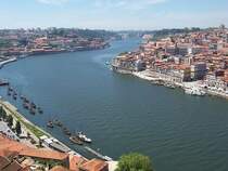 Rechts das Centrum von Porto, links der Stadtteil Vila Nova de Gaia, in der Mitte der Douro in Richtung Westen (Atlantik). Links unten alte Weinschiffe, die Portwein den Douro herab nach Porto bef�rdert haben, dabei soll manches Schiff und Weinfa� zu Bruch gegangen sein, weil der Douro gef�hrliche Klippen im Strom hatte, heute ist er durch drei Schleusen problemlos. Aufgenommen im Mai 2006