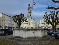 Tittmoning, Florianbrunnen, lebensgro�e Steinfigur des hl. Florian von 1706, achteckiges Brunnenbecken von 1902 (14.02.2016)