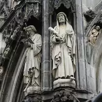 AACHENER DOM-DETAILBILD STEINSKULPTUREN AUSSENFASSADE
Bei meinem letzten Dom-Besuch am 28.4.2017 machte ich dieses Detailbild von Skulpturen des Meisters G�TTING an der Au�enfassade,das mir doch R�tsel aufgab...
Freundlicherweise konnte mir Dombaumeister H. MAINTZ hier weiterhelfen: Bei der rechten Figur,THADD�US,
fehlen Hand und Rest des Buches,die in den letzten Jahrzehnten stark verwittert waren.Die Bruchstellen
wurden nur begradigt,eine Rekonstruktion in den urspr�nglichen Zustand war nicht mehr m�glich.
Bei der linken Figur,JACOBUS MINOR,sind die Zehen ebenfalls stark verwittert....
Man sieht schon,ein Dom ist eine ewige Baustelle-sollte er wirklich mal  fertiggestellt  sein,d�rfte der
Weltuntergang recht nahe sein.....:-)