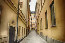 Gasse in der Stockholmer Altstadt (�Gamla Stan�).  In den Geb�uden findet man h�ufig mittelalterliche Kellergew�lbe, Kalkmalereien des 16. Jahrhunderts, reich verzierte Deckenbalken des 17. Jahrhunderts, hochklassige Innenausstattungen im Rokokostil oder �berbordende Dekorationen des 19. Jahrhunderts.
Aufnahme: 25. Juli 2017.