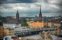 Aussicht von der Plattform am Restaurant Gondolen in Stockholm. Links im Bild ist der Rathausturm zu sehen, in der Mitte die k�nigliche Begr�bniskirche Riddarholmskyrkan.
Aufnahme: 25. Juli 2017.
