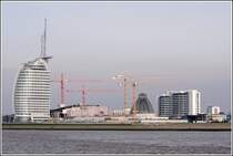 Die Havenwelten in Bremerhaven nehmen Kontur an. Das Atlantic Hotel Sail City steht kurz vor der Er�ffnung (01.03.2008). Unter den roten Kr�nen entsteht das Klimahaus 8� Ost (Fertigstellung M�rz 2009) und unter den gelben Kr�nen geht das Mediterraneo mit seiner hohen Glaskuppel der Vollendung entgegen (Er�ffnung im Sommer 2008). Rechts ist ein Wohnturm des in den 1970er Jahren entstandenen Columbus Centers zu sehen. Aufnahmedatum: 17.02.2008