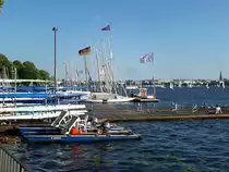 Hamburg am 18.7.2018: Blick vom Park Uhlenhorster F�hrhaus �ber die Au�enalster zum Stadtteil St. Georg, im Vordergrund die Steganlage der „Ruder-Gesellschaft Hansa eV“ und die Liegepl�tze des „Norddeutschen Regatta Verein“ (der dieses Jahr sein 150-j�hriges Bestehen feiert) an der Stra�e „Sch�ne Aussicht“ /